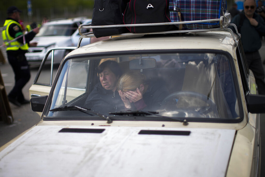 People wait in cars at reception center in Zaporizhzhia