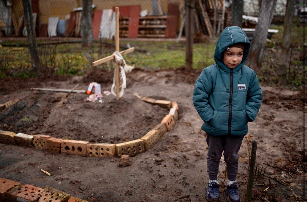 Boy by mother’s grave near Kyiv