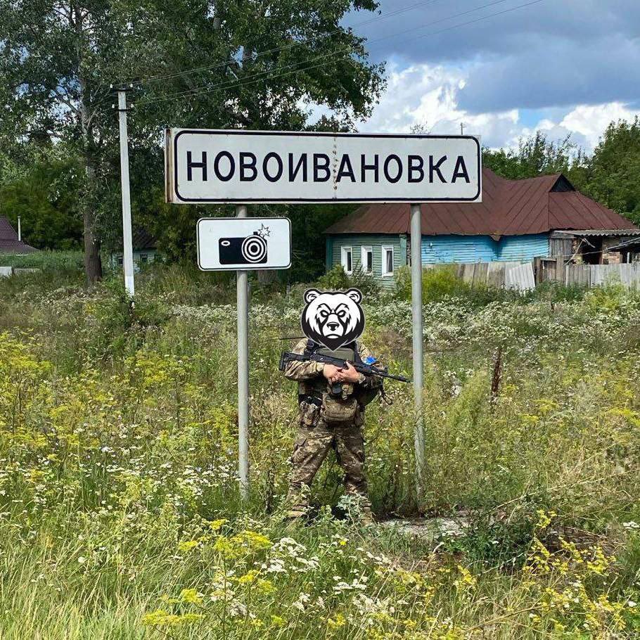 Ukrainian soldiers at Novoivanovka village sign in Kursk region