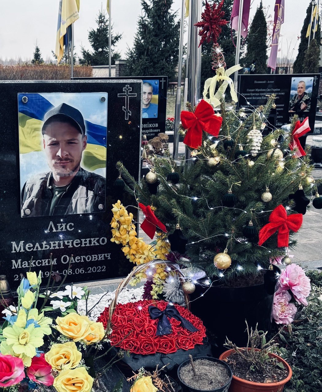 Fallen soldier’s grave in Bucha decorated with Christmas tree lights