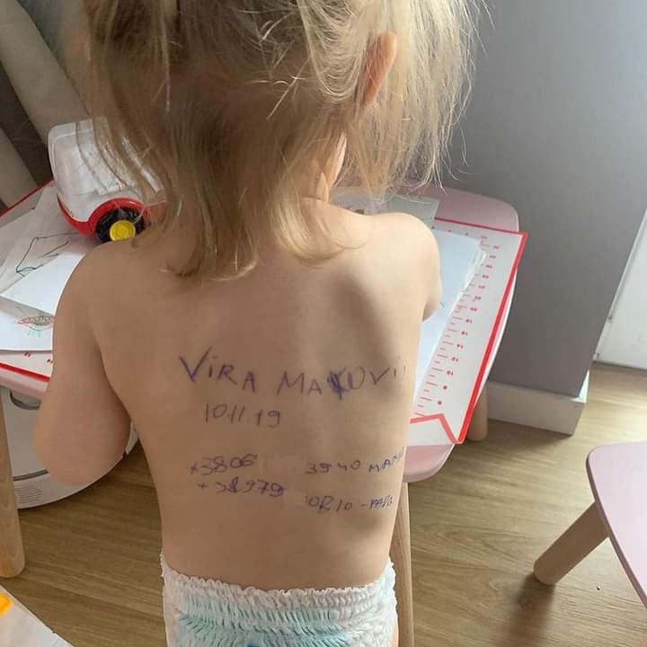 Ukrainian mothers write children’s names and contacts on backs