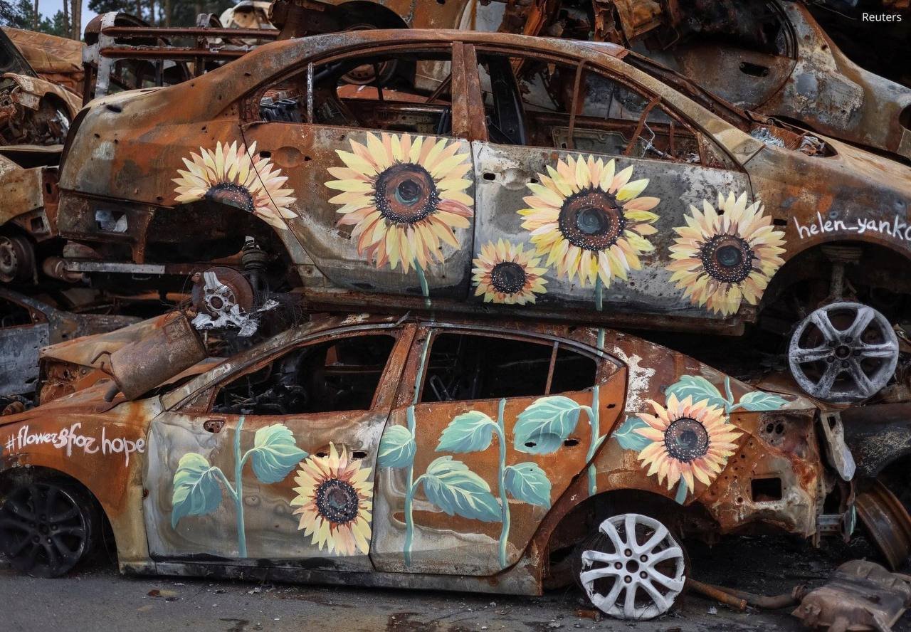 Flowers grow amidst war, symbolizing Ukraine’s fertile land and defiance.
