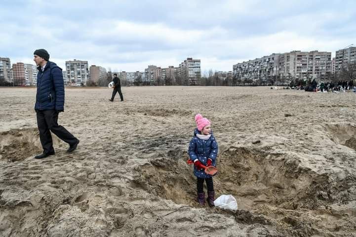 Girl helps build fortifications in front of the city