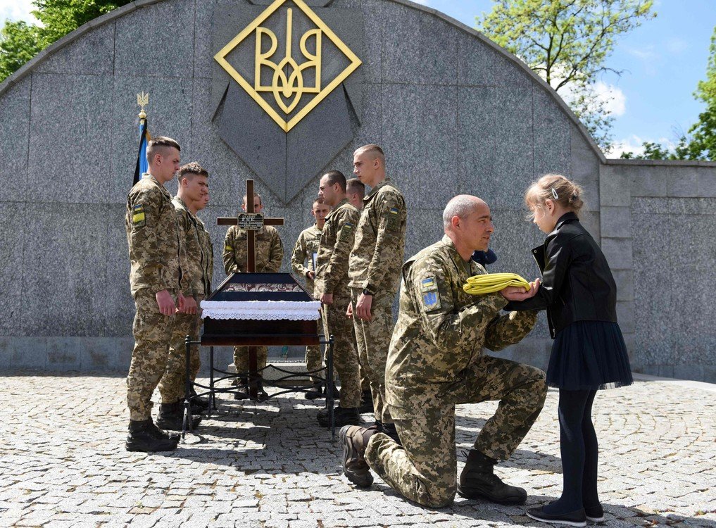 Soldier’s daughter receives Ukrainian flag at father’s funeral in Lviv