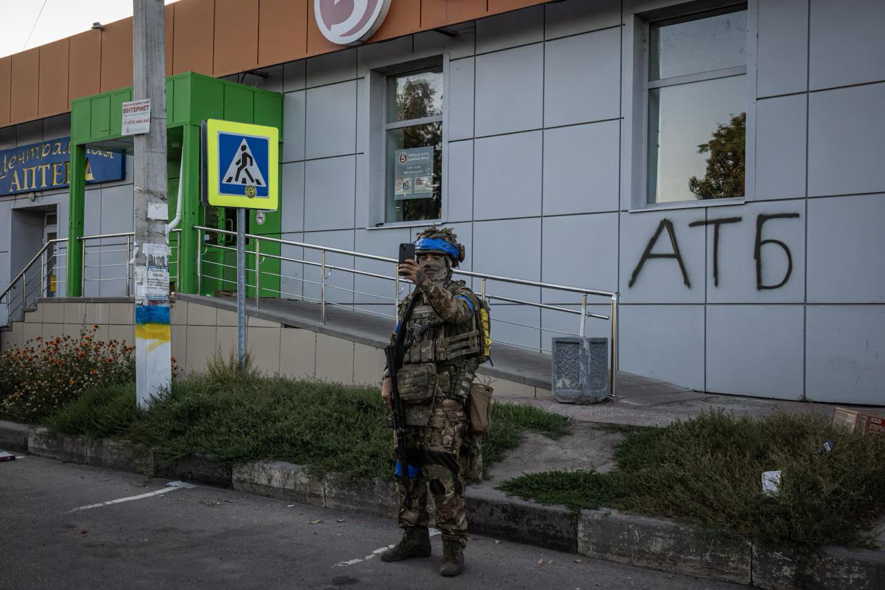 Ukrainian soldier poses near renamed store in Kursk