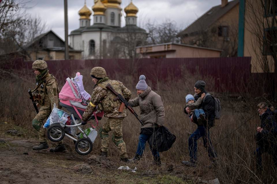 Ukrainian defenders help a fleeing family cross the river